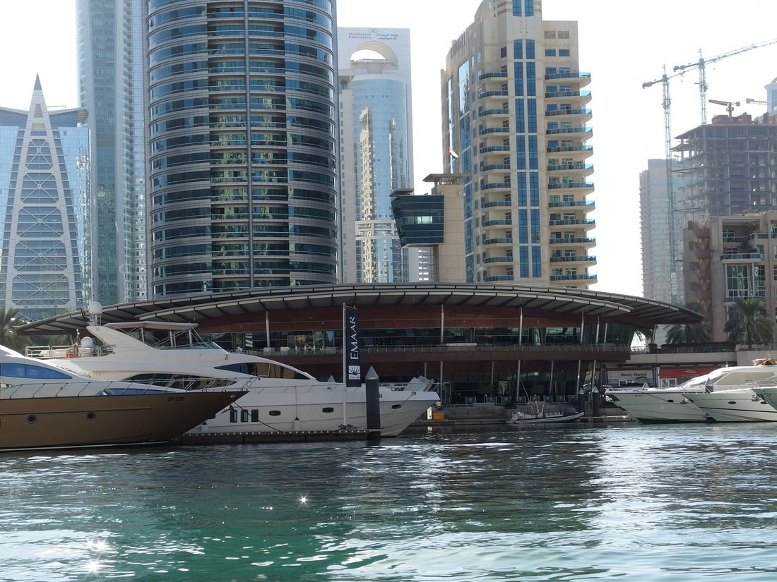 Boats moored in a marina in Dubai at dusk
